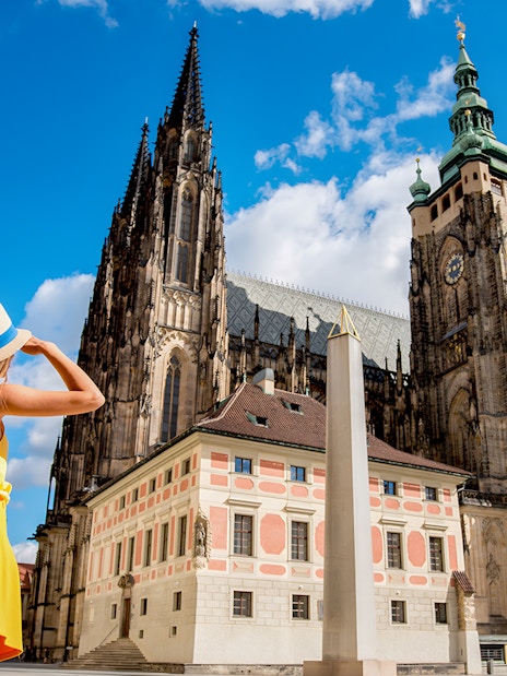 Woman admiring St. Vitus Cathedral in Prague Castle complex, Czech Republic.