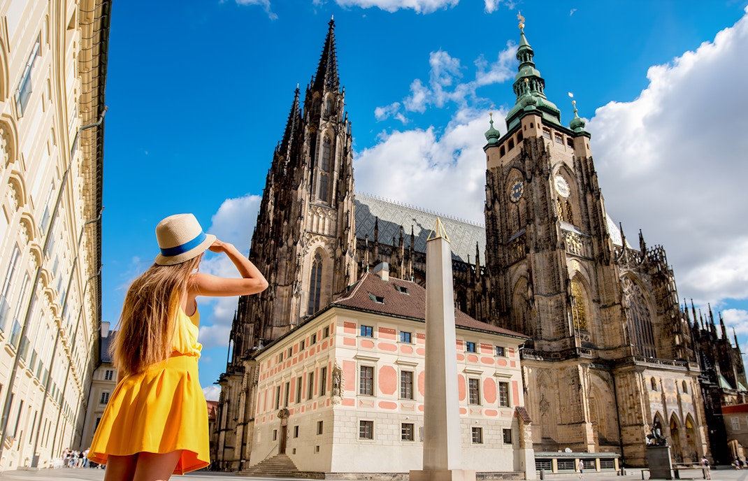 Woman admiring St. Vitus Cathedral in Prague Castle complex, Czech Republic.