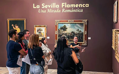 Visitors at Tablao Casa de la Memoria viewing flamenco-themed art exhibit in Seville.