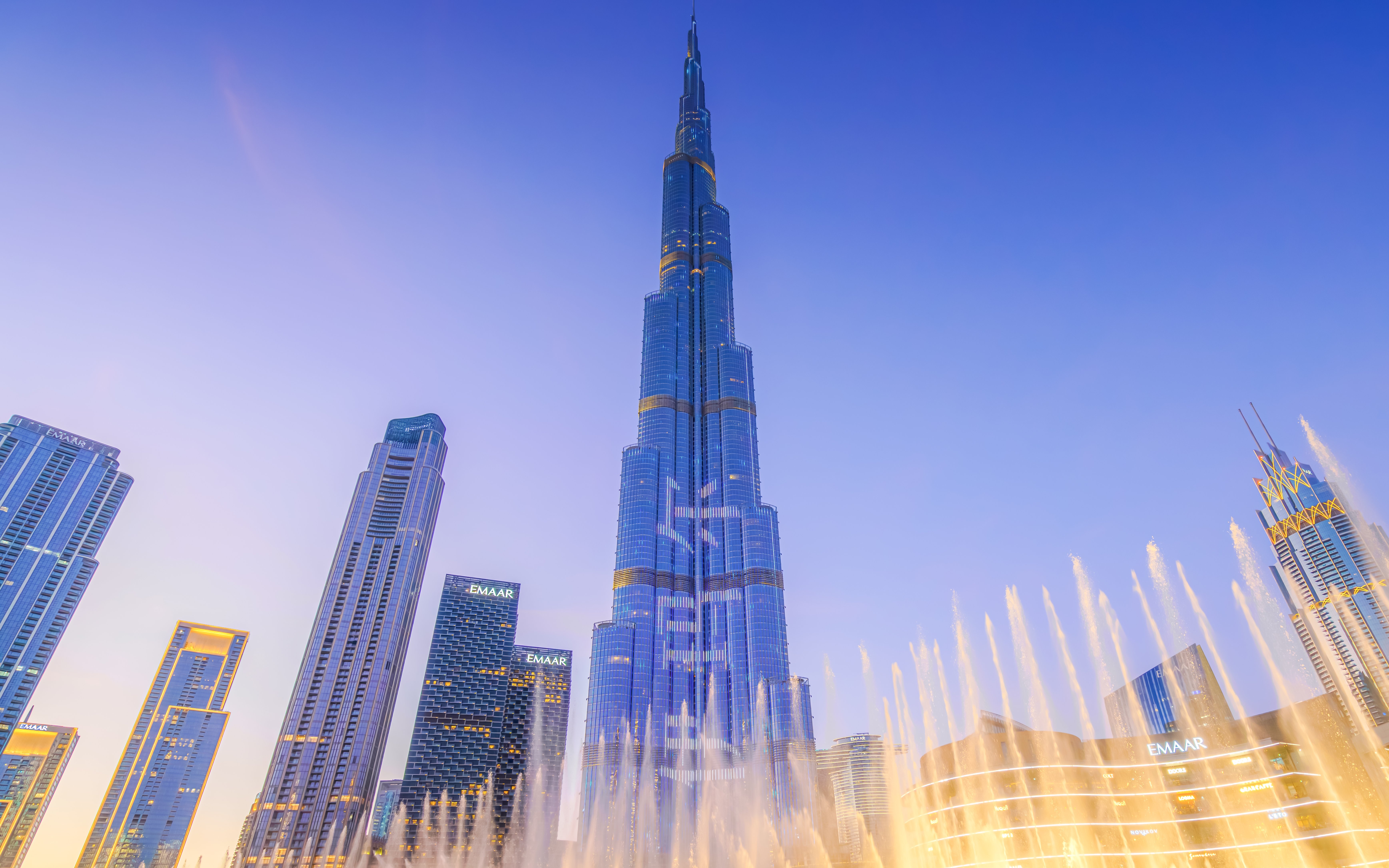 Dubai Fountain show with Burj Khalifa illuminated at night.