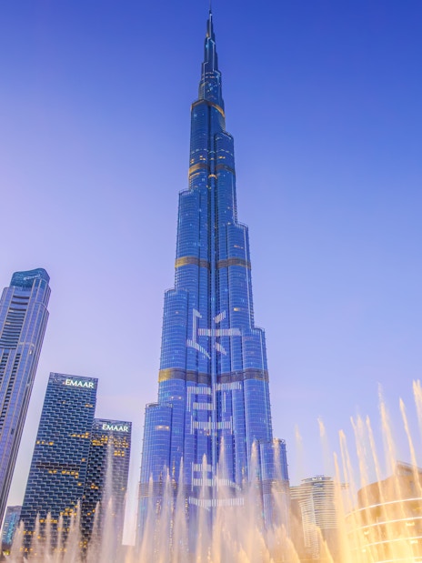 Dubai Fountain show with Burj Khalifa illuminated at night.