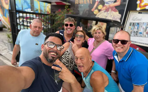 Group enjoying Miami Calle Ocho Walking Tour with Cuban coffee backdrop.