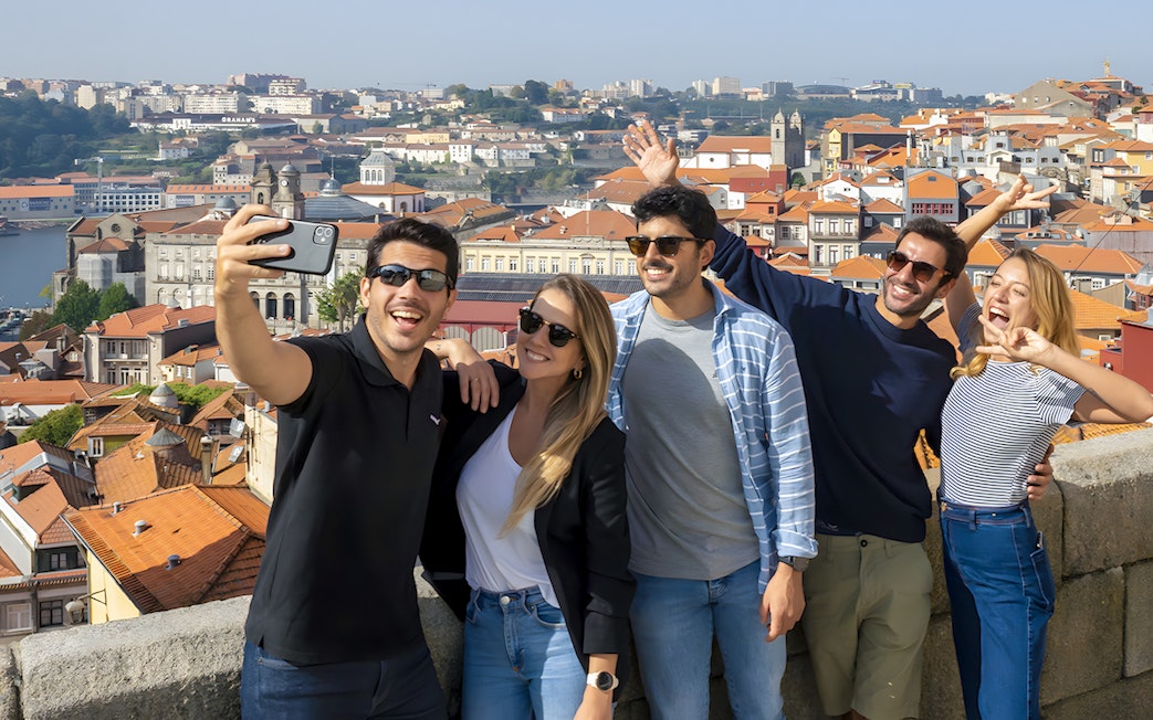 Tourists taking a selfie with a guide overlooking Porto's cityscape during a walking tour.