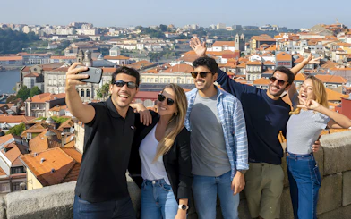 Tourists taking a selfie with a guide overlooking Porto's cityscape during a walking tour.