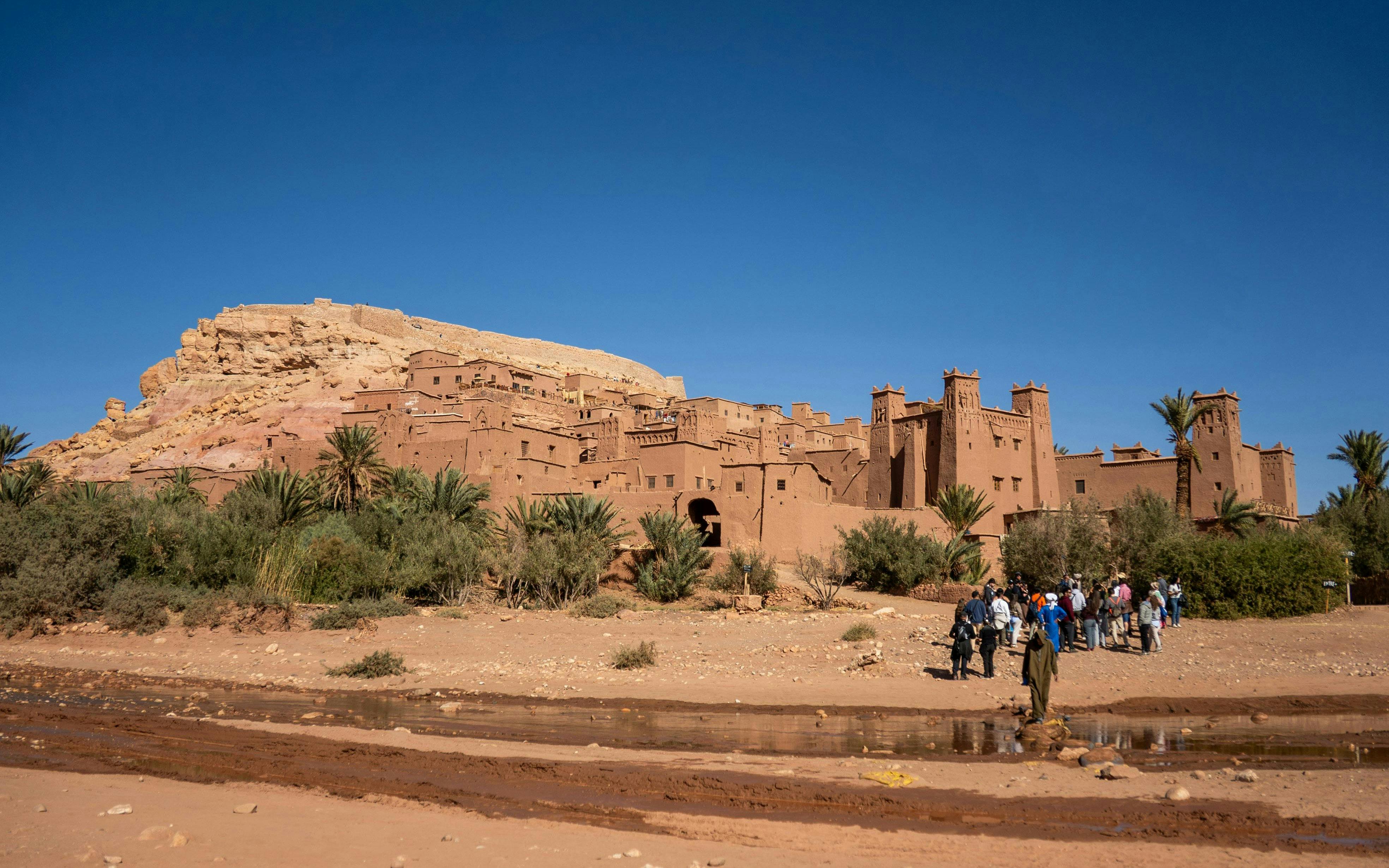 Tourists exploring the fortified city walls of Ait Benhaddou, Morocco.