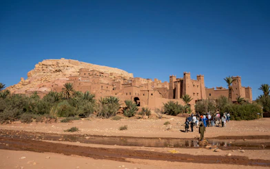 Tourists exploring the fortified city walls of Ait Benhaddou, Morocco.
