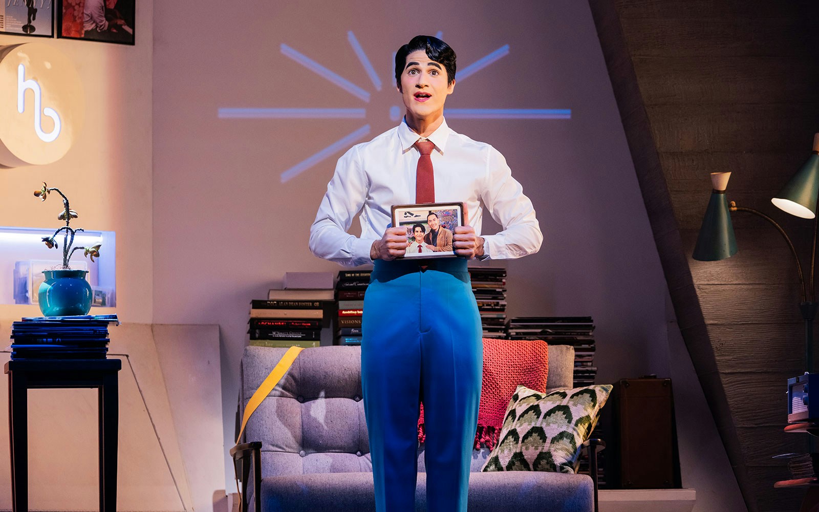 Performer holding a framed photo on stage during Maybe Happy Ending Broadway show.
