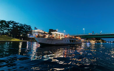 Sightseeing cruise boat on the Vistula River in Krakow at dusk.