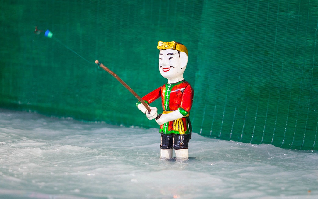 Water puppet in traditional attire performing at Golden Water Puppet Show.