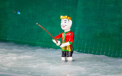 Water puppet in traditional attire performing at Golden Water Puppet Show.