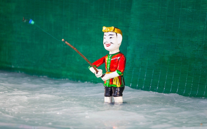 Water puppet in traditional attire performing at Golden Water Puppet Show.