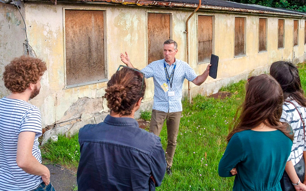 Tour guide explaining Sachsenhausen Concentration Camp Memorial to visitors.