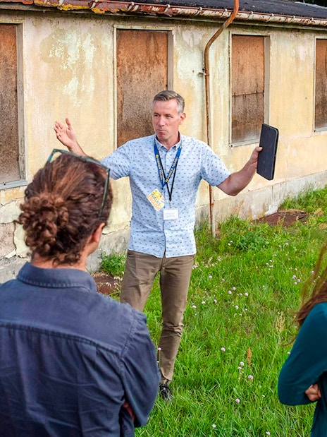 Tour guide explaining Sachsenhausen Concentration Camp Memorial to visitors.