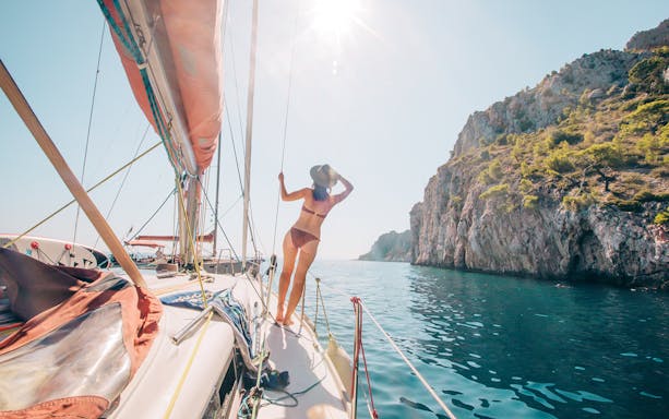 Sailing yacht near rocky coastline of Hvar and Pakleni Islands.