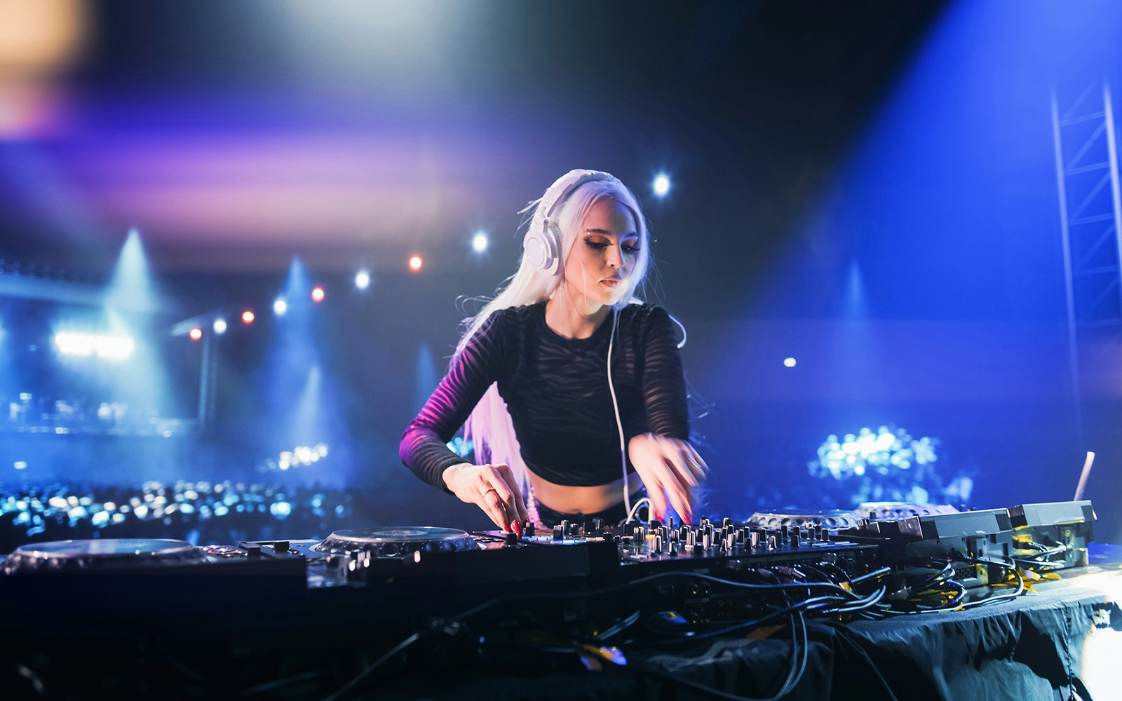 DJ performing at a vibrant music festival in a lively outdoor setting.