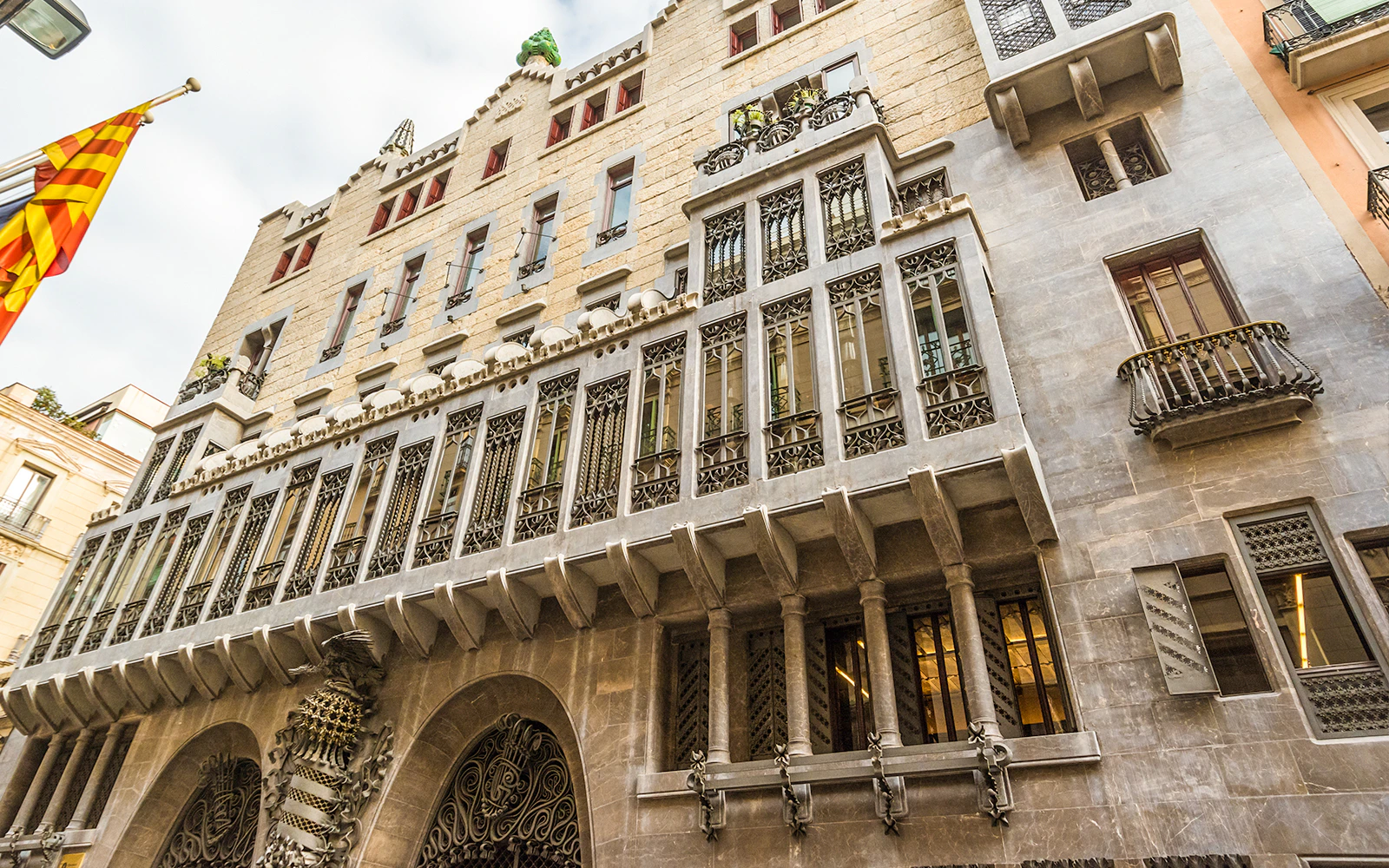 Palau Güell facade with ornate ironwork and stone arches in Barcelona.