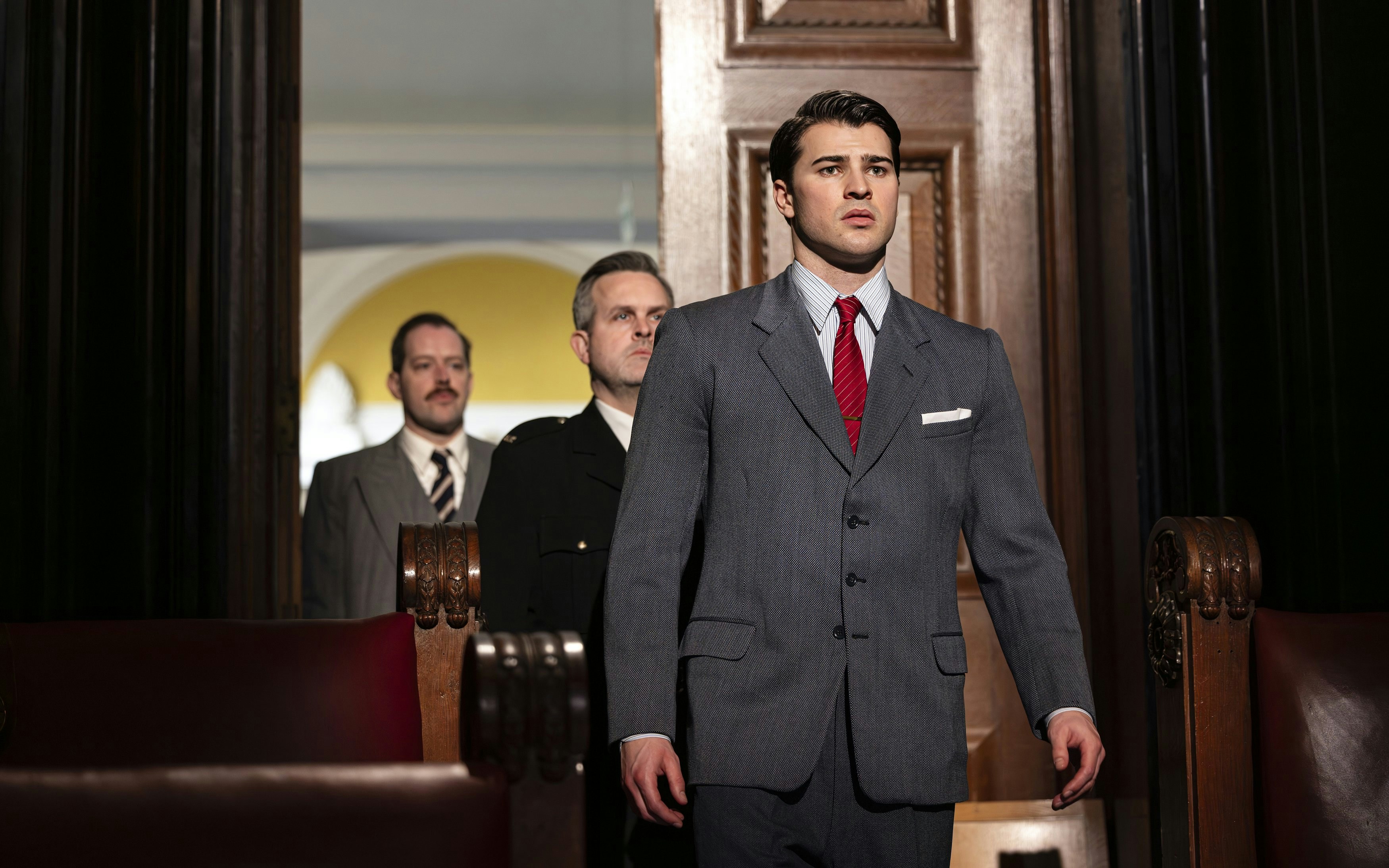 Courtroom scene from "Witness for the Prosecution" performance with actors in suits.