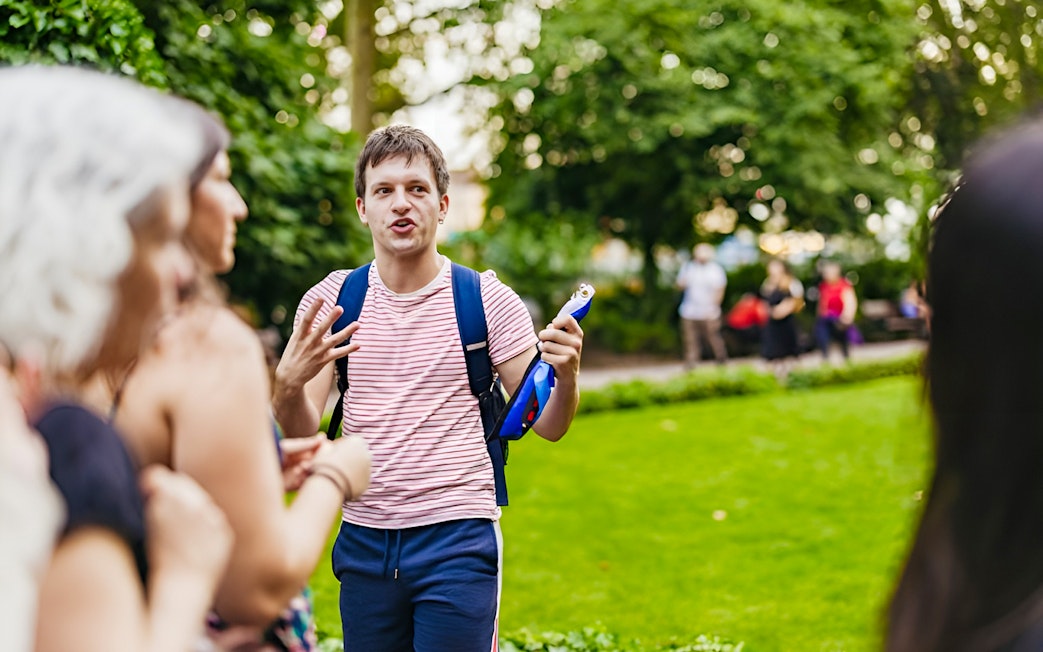 Tour guide leading Harry Potter film locations tour in London park.