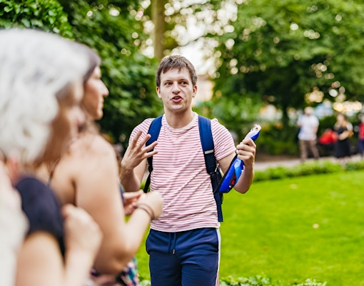 Tour guide leading Harry Potter film locations tour in London park.