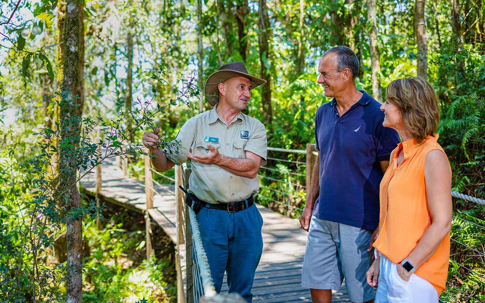 Guide explaining plants to tourists on a Kuranda rainforest boardwalk tour.