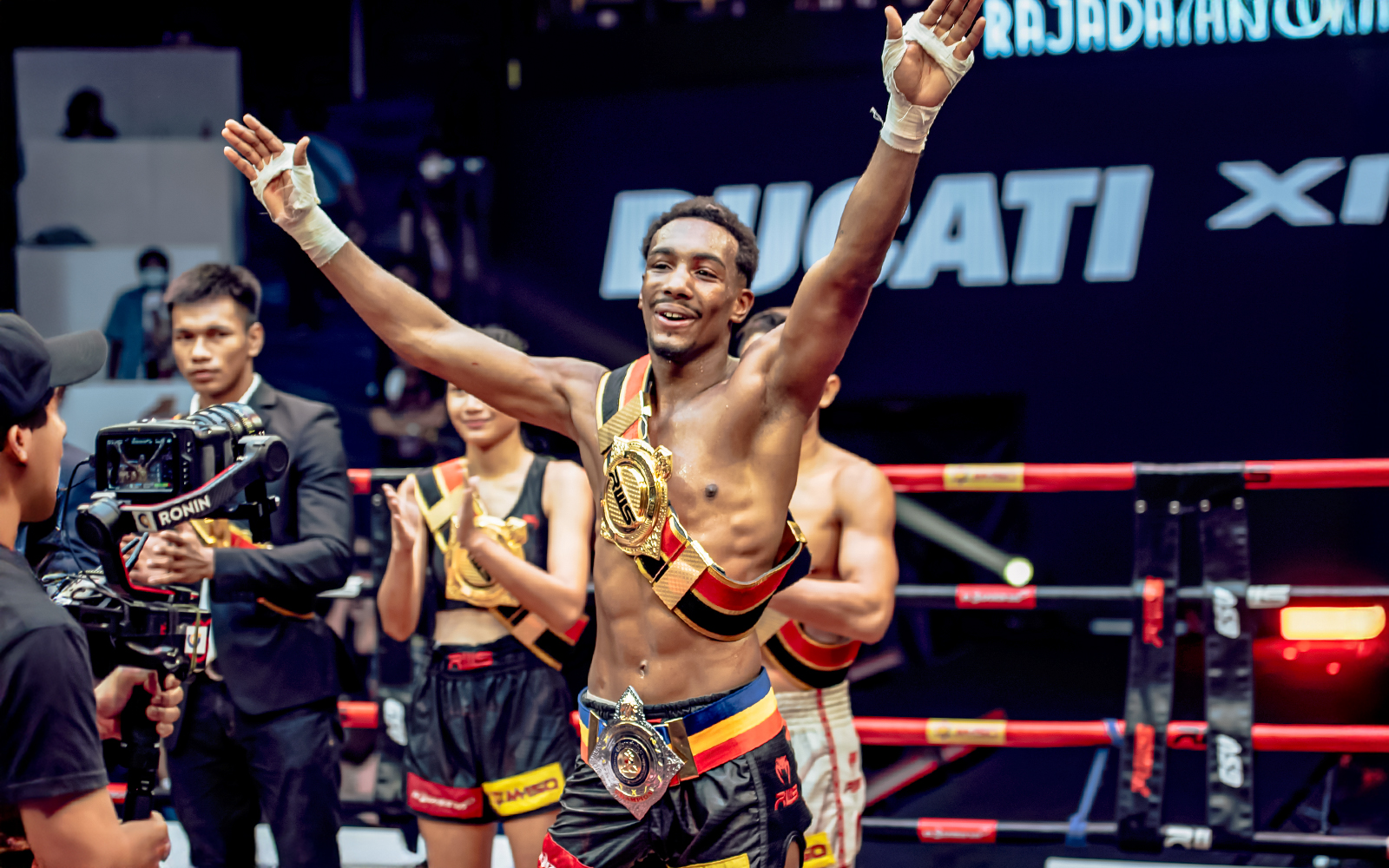 Muay Thai fighter celebrating victory at Rajadamnern Boxing Stadium, Bangkok.