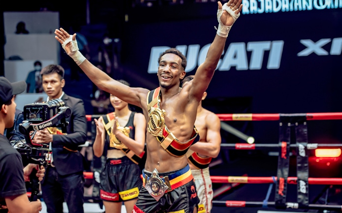 Muay Thai fighter celebrating victory at Rajadamnern Boxing Stadium, Bangkok.
