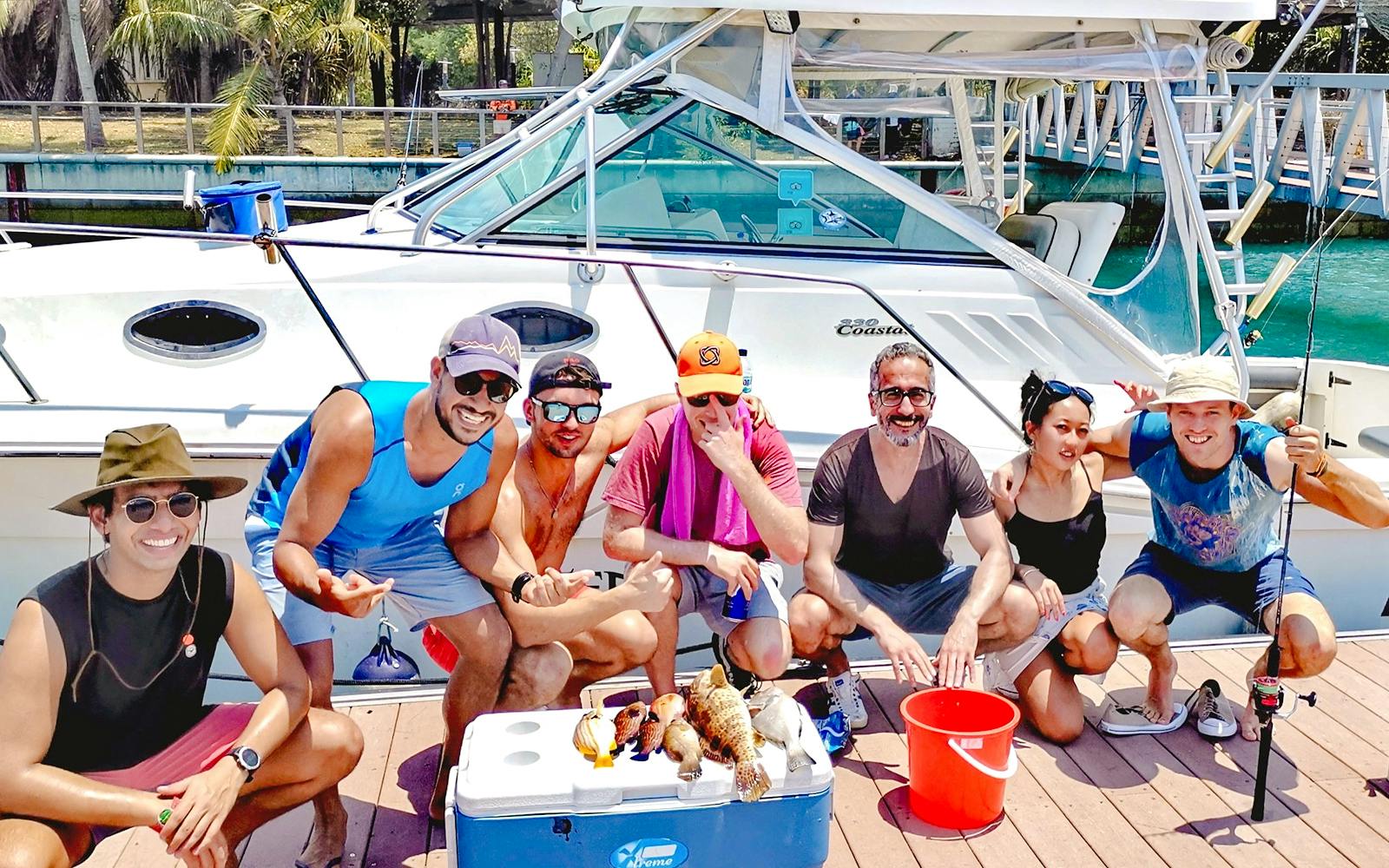 Group of people with fish catch on yacht fishing trip.