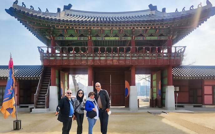 Visitors at a traditional Korean gate during a guided tour in Seoul.