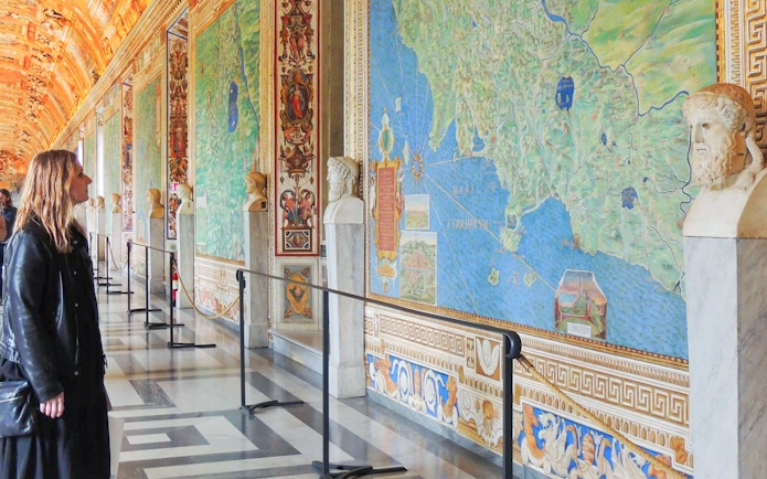 Visitor admiring detailed frescoes in the Vatican Gallery of Maps, Vatican City.