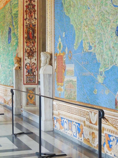 Visitor admiring detailed frescoes in the Vatican Gallery of Maps, Vatican City.