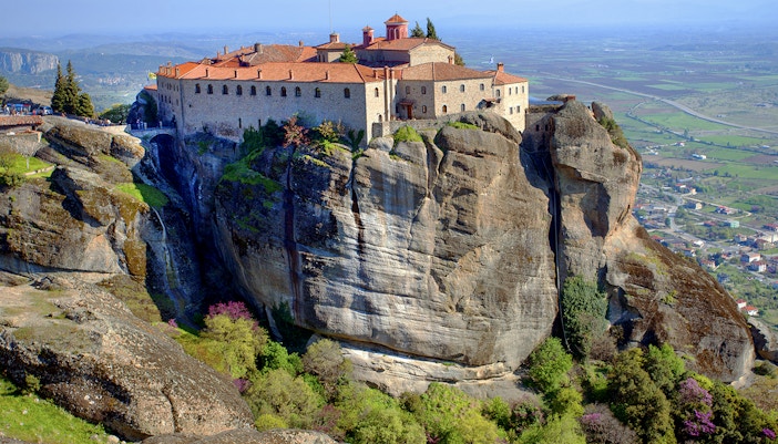 Meteora monastery perched on a rocky cliff with panoramic views of the Thessaly Valley, Greece.