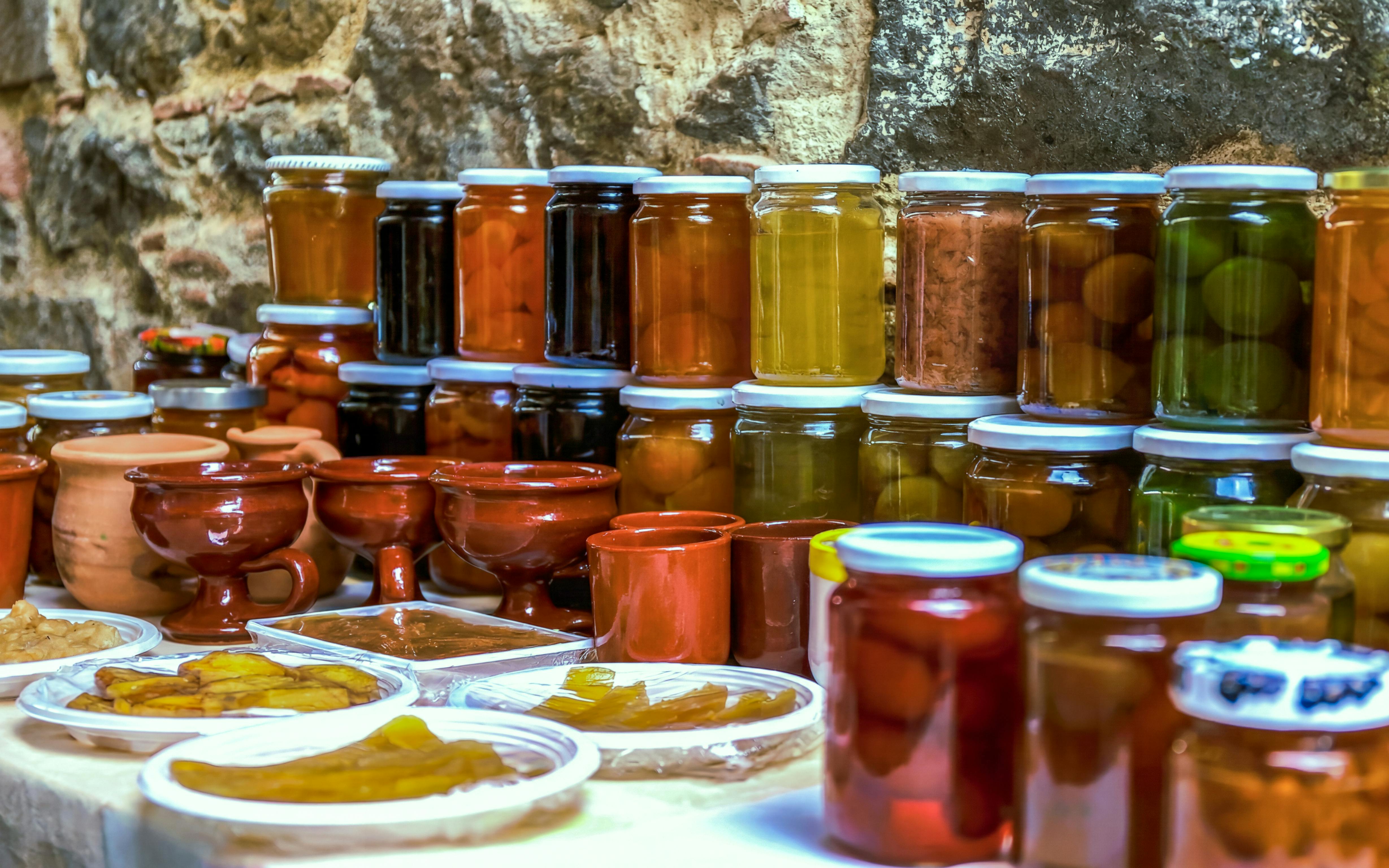 Jars of local preserves and pottery on display during Troodos Mountains gourmet tour.
