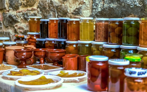 Jars of local preserves and pottery on display during Troodos Mountains gourmet tour.
