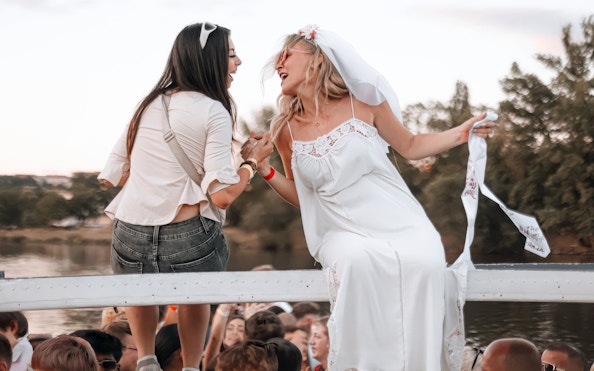 People celebrating on a boat cruise, enjoying the scenic river view.