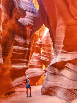 Visitor exploring the sandstone formations of Upper Antelope Canyon, Arizona.