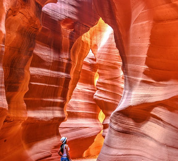 Visitor exploring the sandstone formations of Upper Antelope Canyon, Arizona.