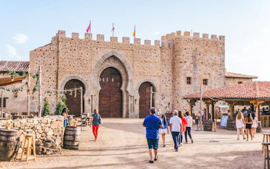 Visitors entering medieval stone gate at Puy du Fou España park.