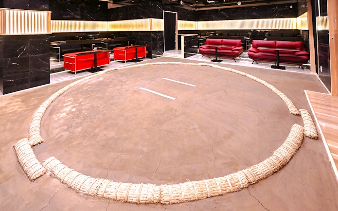 Wrestling ring at Asakusa Sumo club, Tokyo with seating area in background.