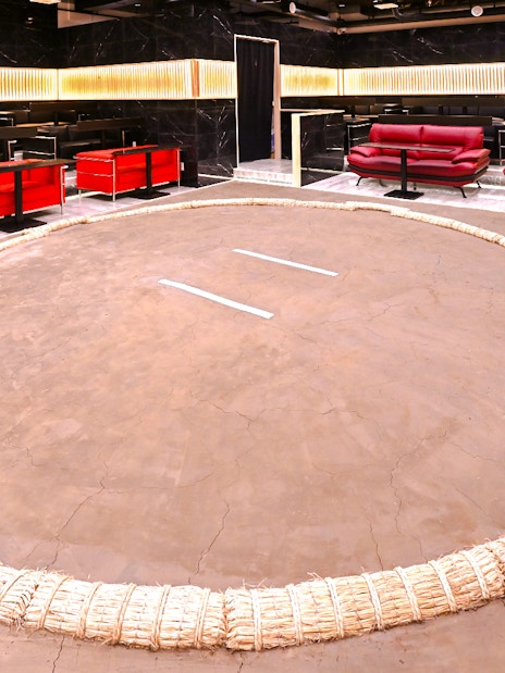 Wrestling ring at Asakusa Sumo club, Tokyo with seating area in background.