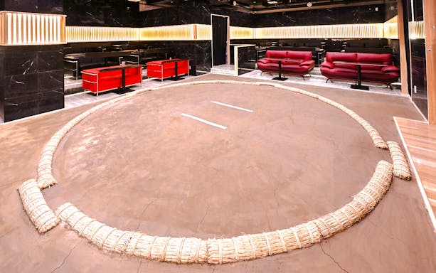 Wrestling ring at Asakusa Sumo club, Tokyo with seating area in background.