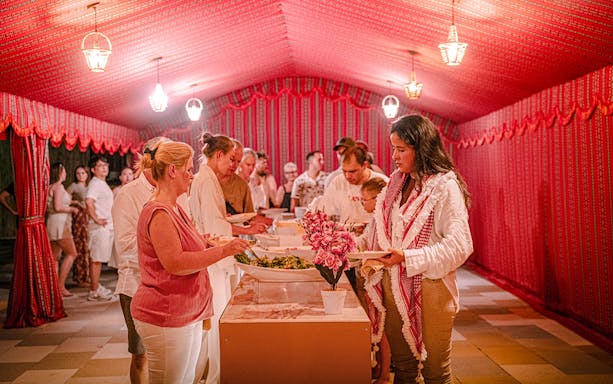 Guests serving themselves dinner at Abu Dhabi desert safari buffet.