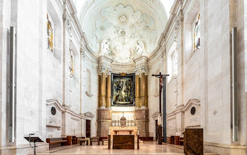 Interior view of the Sanctuary of Fatima, Portugal, featuring altar and religious artwork.