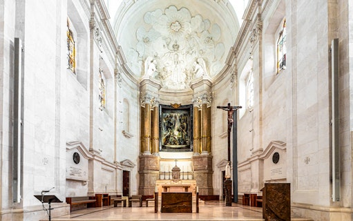 Interior view of the Sanctuary of Fatima, Portugal, featuring altar and religious artwork.