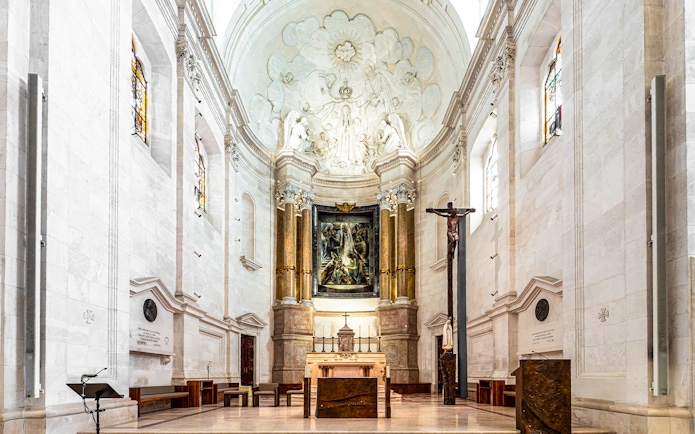 Interior view of the Sanctuary of Fatima, Portugal, featuring altar and religious artwork.