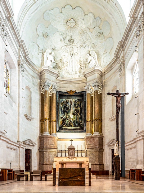 Interior view of the Sanctuary of Fatima, Portugal, featuring altar and religious artwork.