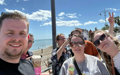Group enjoying ice cream by the beach during Benalmádena Pueblo self-guided city exploration game.