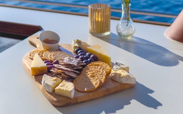 Cheese and crackers platter on a table by the water in Oslo.