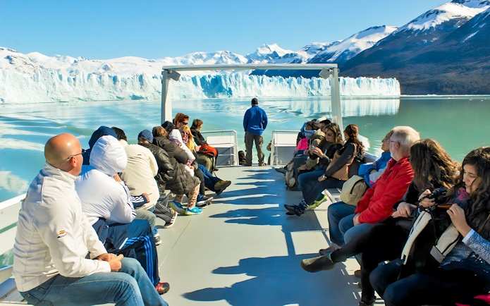 Tourists on Perito Moreno Cruise deck viewing glacier in Argentina.