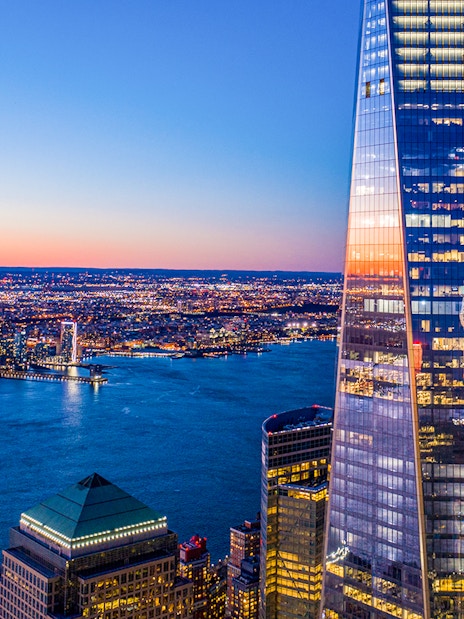 One World Observatory view at sunset over New York City skyline and Hudson River.
