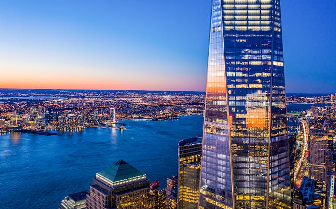 One World Observatory view at sunset over New York City skyline and Hudson River.